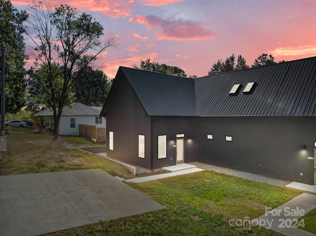 view of front of home featuring a lawn and a patio area