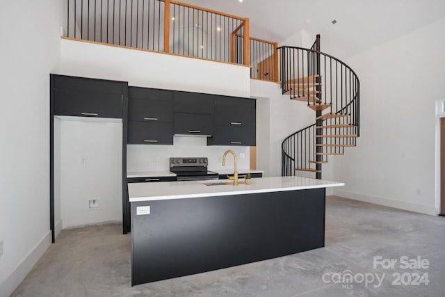 kitchen with a kitchen island with sink, stainless steel electric range oven, and a high ceiling