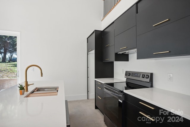 kitchen with a towering ceiling, sink, and black electric range