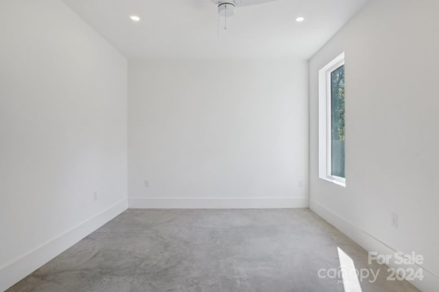 carpeted spare room with a healthy amount of sunlight and ceiling fan