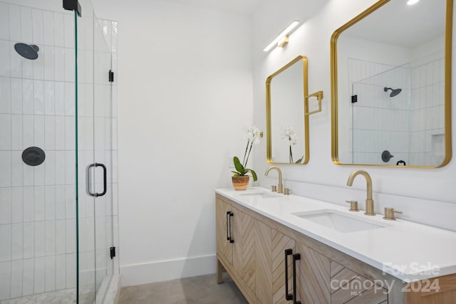 bathroom with a shower with shower door and vanity