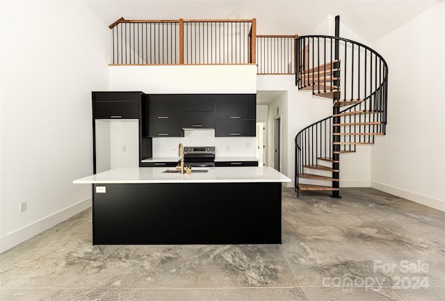 kitchen with an island with sink and high vaulted ceiling