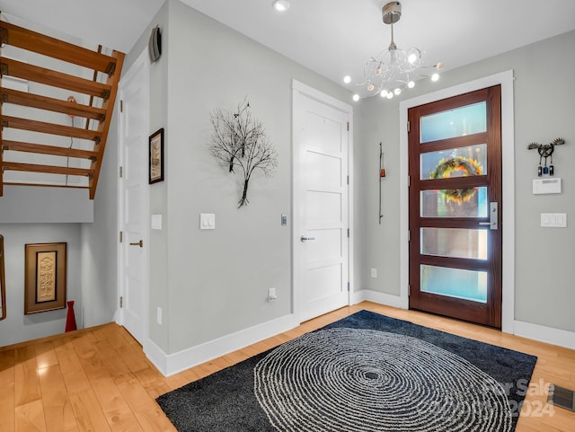 foyer featuring wood-type flooring and an inviting chandelier