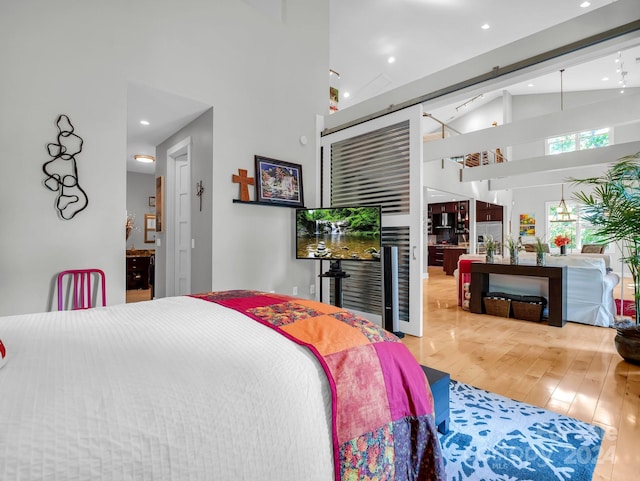 bedroom with a closet, high vaulted ceiling, and hardwood / wood-style flooring