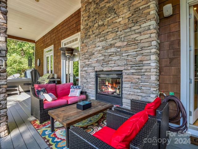 wooden terrace featuring grilling area and an outdoor living space with a fireplace