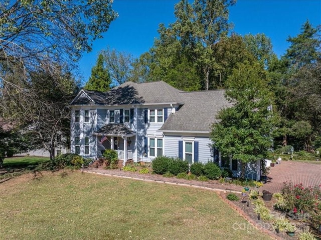 colonial-style house featuring a front lawn