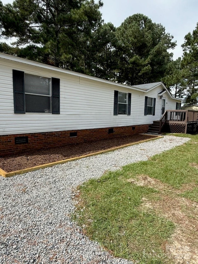 exterior space with a wooden deck and a front yard