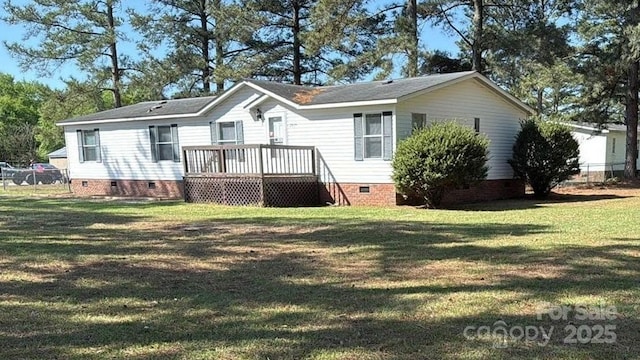 rear view of property featuring crawl space, a wooden deck, fence, and a lawn