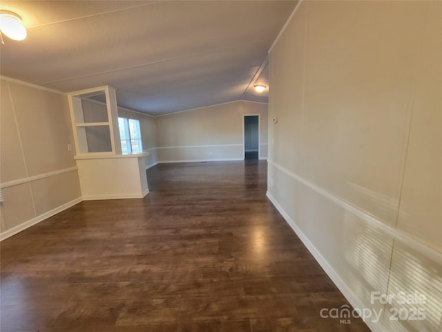 interior space featuring dark wood-style flooring and lofted ceiling