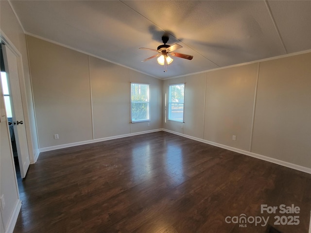 spare room featuring ornamental molding, ceiling fan, vaulted ceiling, and dark wood-style floors