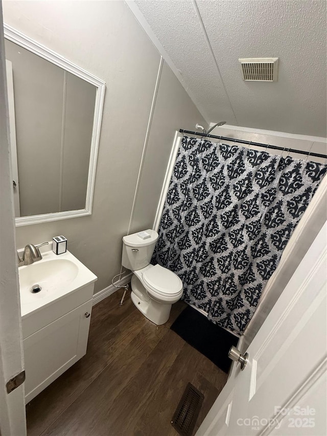 bathroom with visible vents, toilet, vanity, and wood finished floors