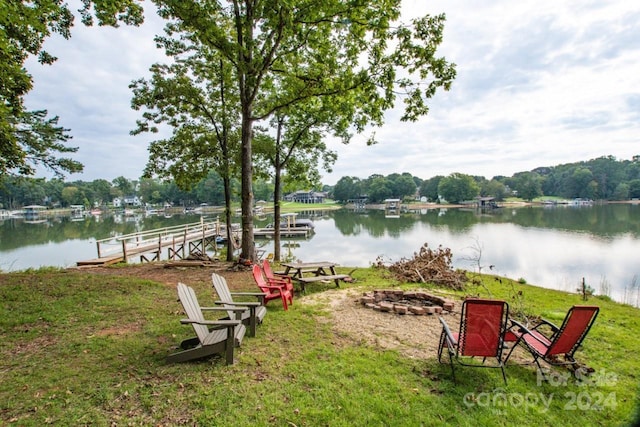 exterior space featuring a boat dock, a water view, and a fire pit