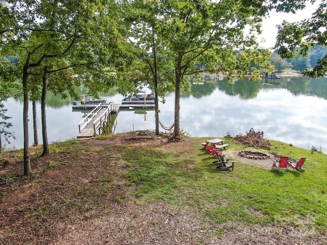 exterior space featuring a boat dock, a water view, and a fire pit