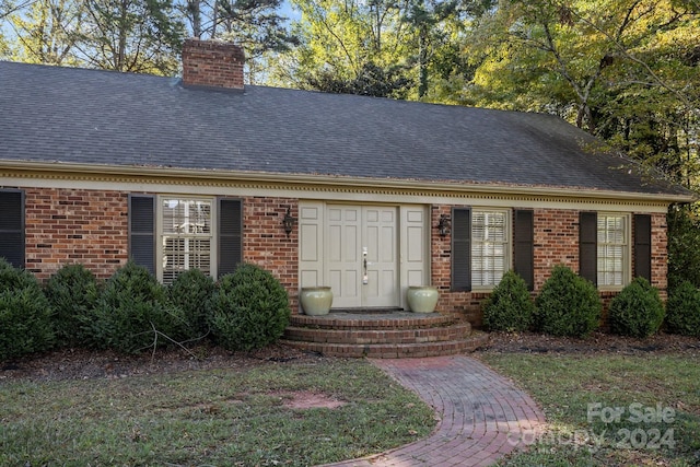 view of exterior entry with a lawn