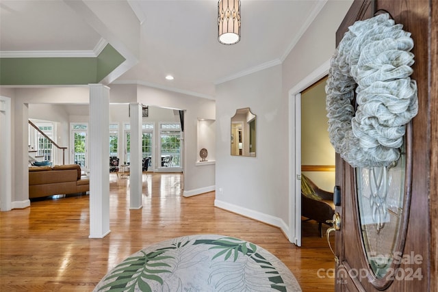 entrance foyer with light hardwood / wood-style flooring and ornamental molding