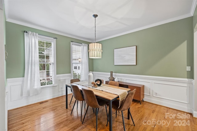 dining area with ornamental molding and light wood-type flooring