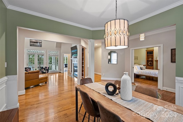 dining room with crown molding and light hardwood / wood-style floors