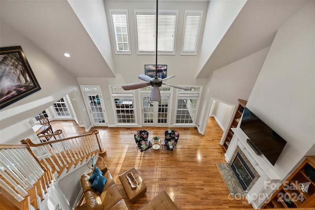 living room featuring a high ceiling, ceiling fan, and hardwood / wood-style flooring