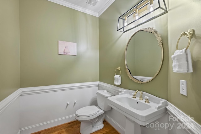 bathroom featuring crown molding, hardwood / wood-style floors, and toilet