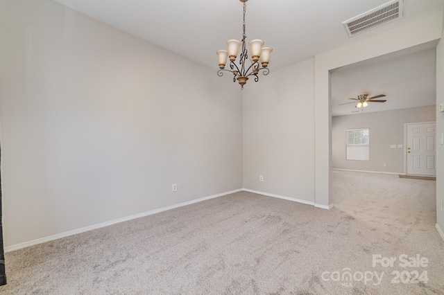 empty room with ceiling fan with notable chandelier and carpet flooring