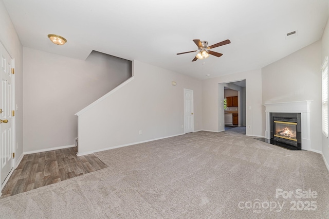 4803 Roxfield Ln, Charlotte, NC 28215 - unfurnished living room with stairs, carpet floors, a fireplace with flush hearth, a ceiling fan, and baseboards