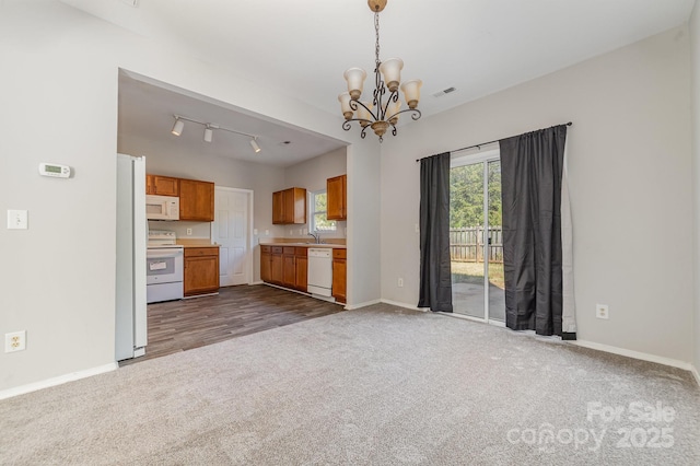 4803 Roxfield Ln, Charlotte, NC 28215 - unfurnished living room with dark colored carpet, a chandelier, baseboards, a sink, and track lighting