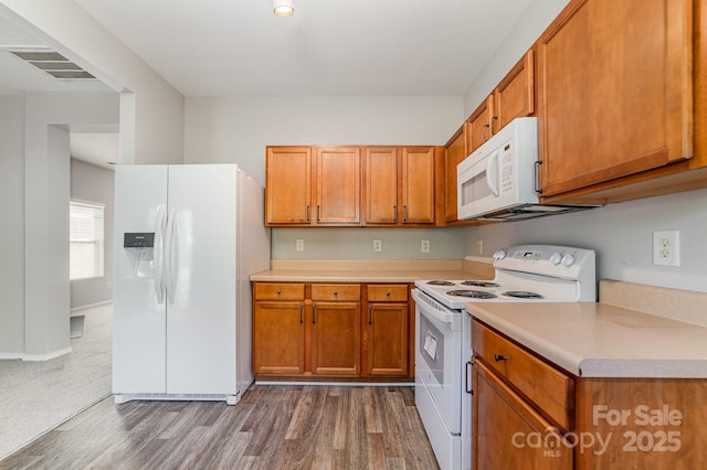 4803 Roxfield Ln, Charlotte, NC 28215 - kitchen with white appliances, light countertops, dark wood finished floors, and brown cabinetry