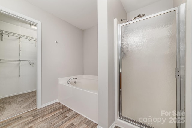 4803 Roxfield Ln, Charlotte, NC 28215 - full bath featuring a stall shower, a bath, wood finished floors, a spacious closet, and baseboards