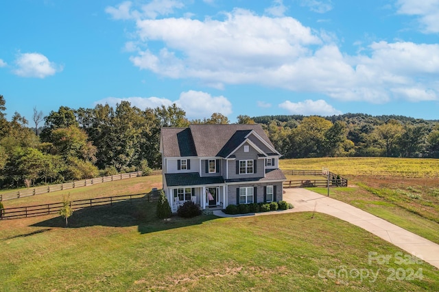 view of front facade with a rural view and a front lawn