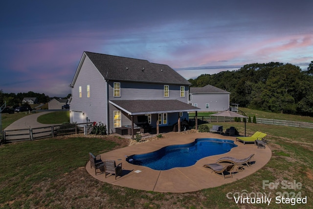 pool at dusk featuring a yard and a patio area