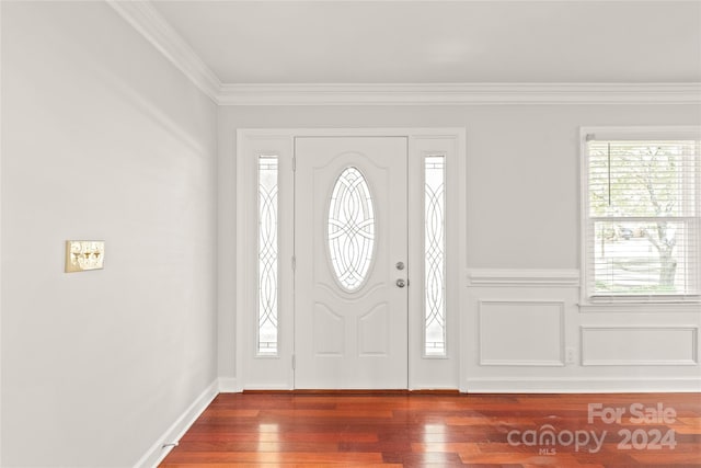 foyer featuring crown molding and dark wood-type flooring