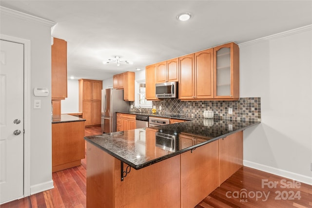 kitchen featuring crown molding, appliances with stainless steel finishes, kitchen peninsula, and wood-type flooring