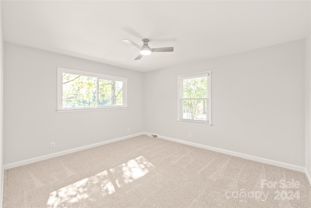 empty room with a healthy amount of sunlight, carpet, and ceiling fan