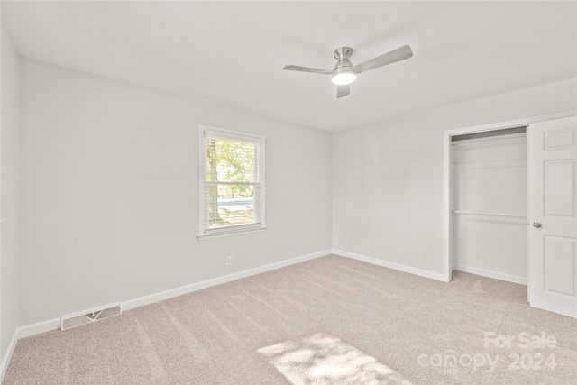 unfurnished bedroom featuring a closet, ceiling fan, and light carpet