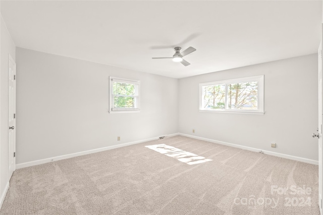 carpeted spare room with a healthy amount of sunlight and ceiling fan