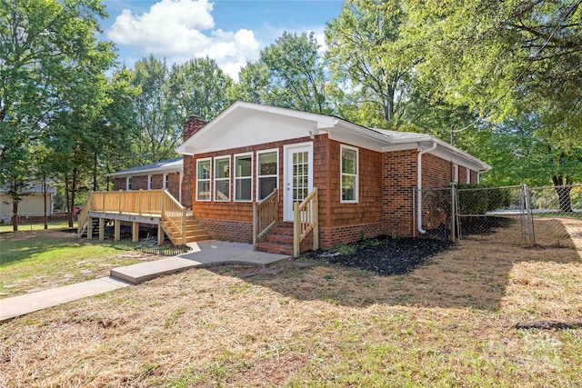 view of front of house featuring a front yard and a deck