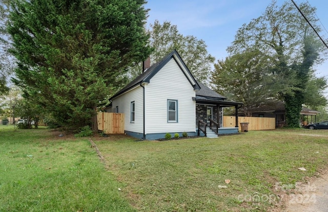 view of side of home with a yard