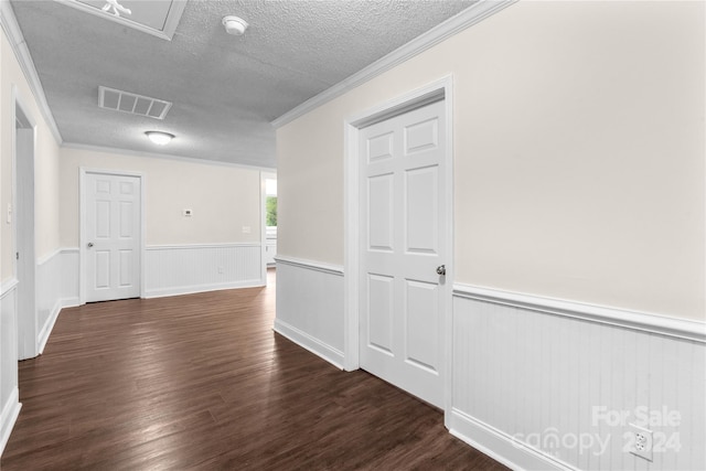 corridor with a textured ceiling, ornamental molding, and dark hardwood / wood-style floors