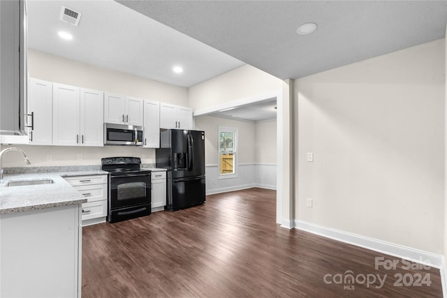 kitchen featuring light stone counters, sink, dark wood-type flooring, white cabinetry, and black appliances