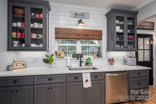 bar featuring gray cabinetry, dishwasher, sink, ornamental molding, and light hardwood / wood-style floors