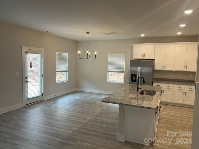 kitchen featuring white cabinetry, stainless steel fridge with ice dispenser, wood-type flooring, and decorative light fixtures