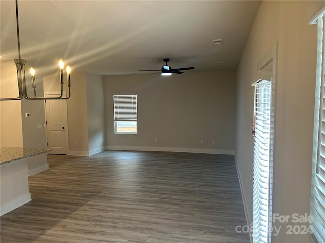 unfurnished living room with dark hardwood / wood-style floors and ceiling fan