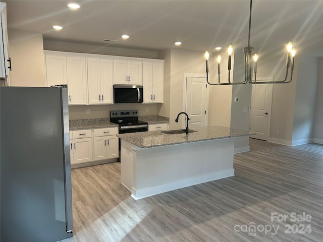 kitchen with white cabinets, stainless steel appliances, a center island with sink, and sink