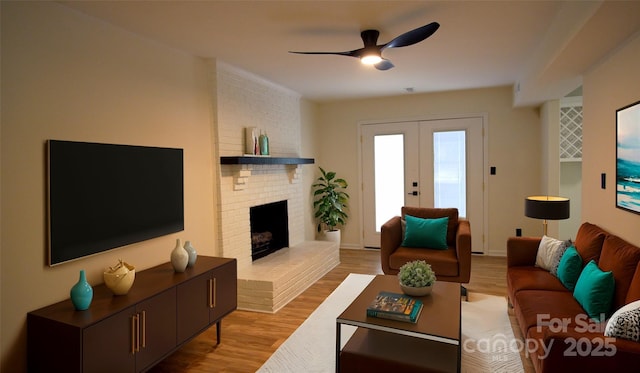 living room featuring ceiling fan, french doors, a fireplace, and light hardwood / wood-style flooring