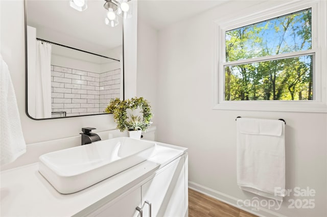 bathroom featuring vanity, hardwood / wood-style flooring, walk in shower, and a healthy amount of sunlight