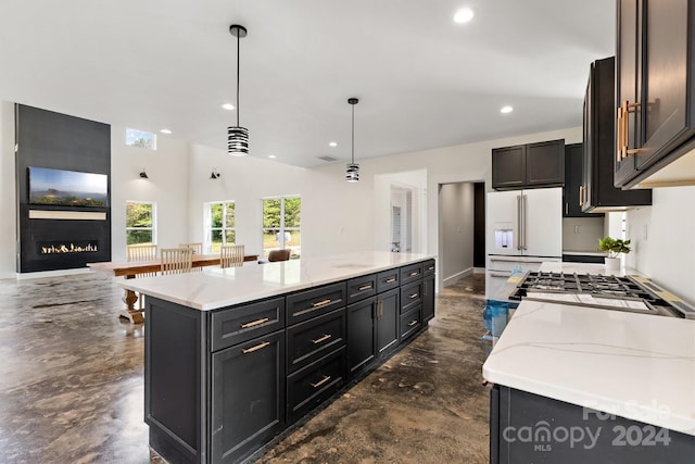 kitchen with a kitchen island, white fridge with ice dispenser, and decorative light fixtures