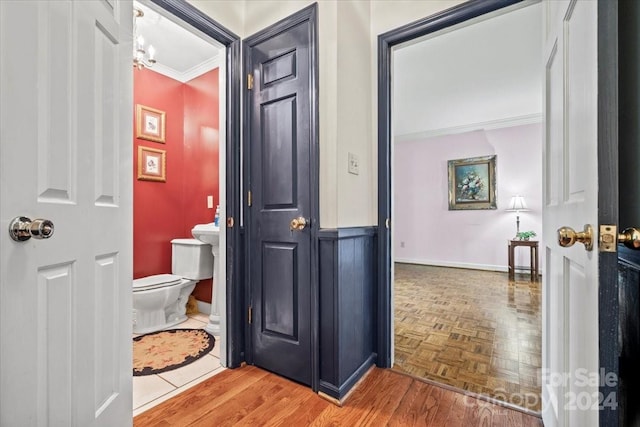 bathroom with ornamental molding, toilet, and parquet flooring