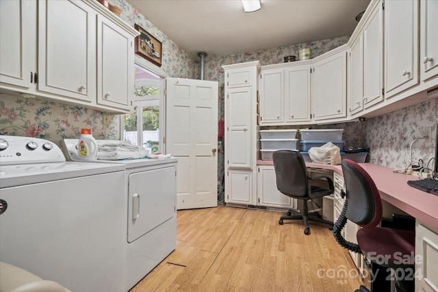 clothes washing area featuring washer and dryer, light hardwood / wood-style flooring, and cabinets