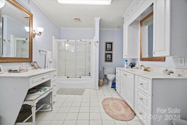 full bathroom featuring enclosed tub / shower combo, vanity, ornamental molding, tile patterned floors, and toilet