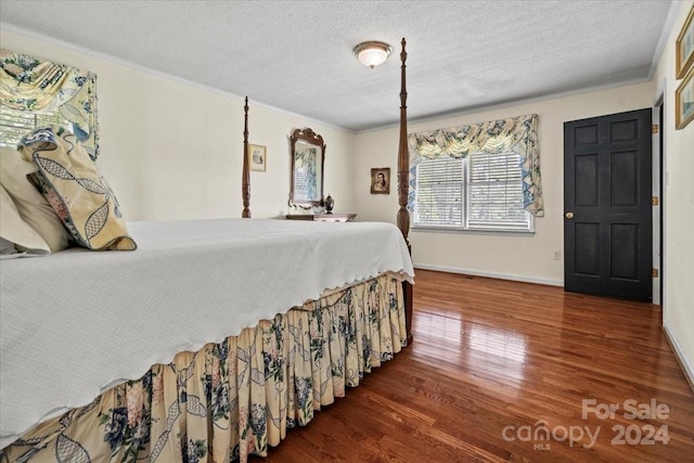 bedroom featuring crown molding, hardwood / wood-style flooring, and a textured ceiling